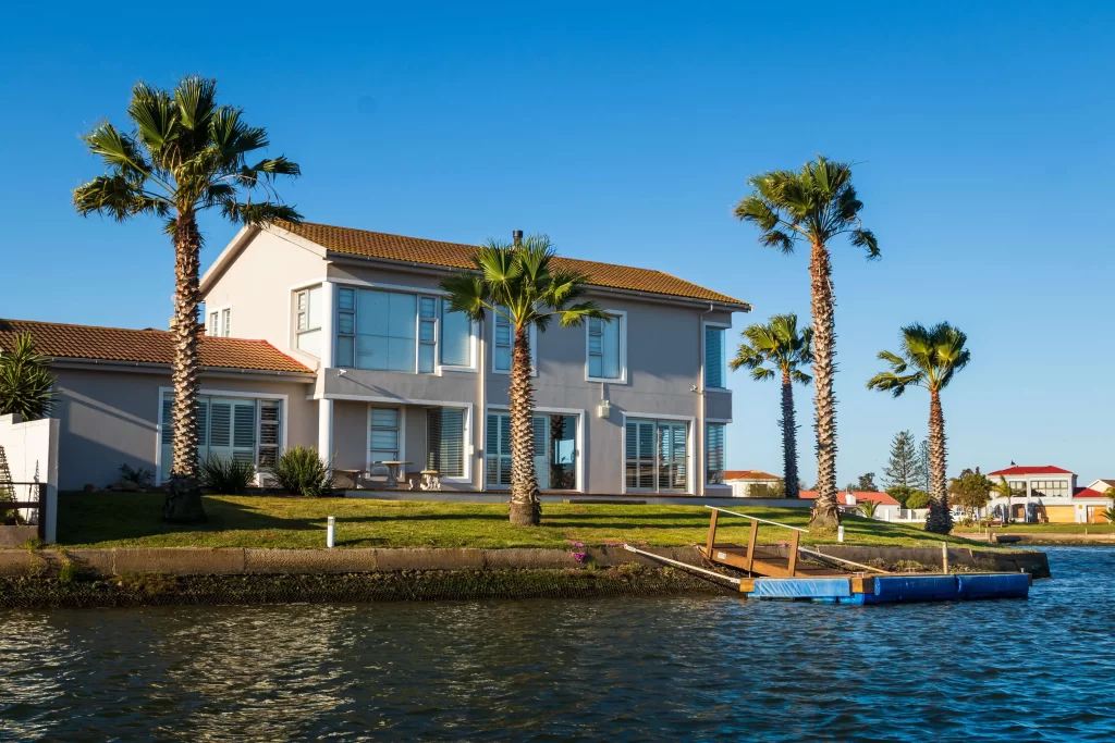 How to Handle Short-Term Rentals in HOAs 1 house with palm trees on a canal an example of a short term rentals in HOAs