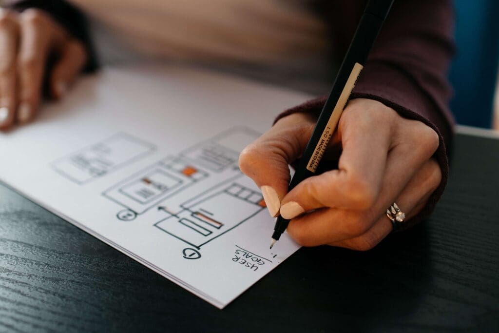 How Do You Prepare an HOA Emergency Communication Plan? 1 hoa emergency communication - a hand holds a pen and adds to a plan