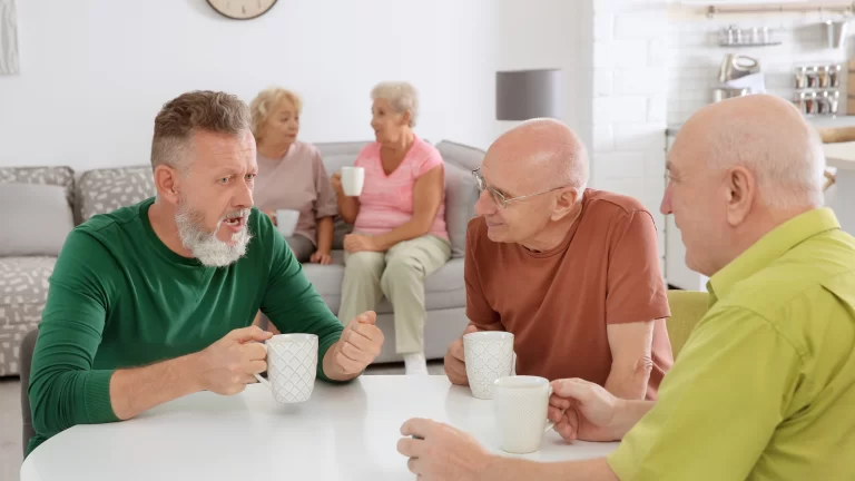 Benefits of being on an HOA board: 5 HOA board members having an informal meeting. They are having coffee and talking