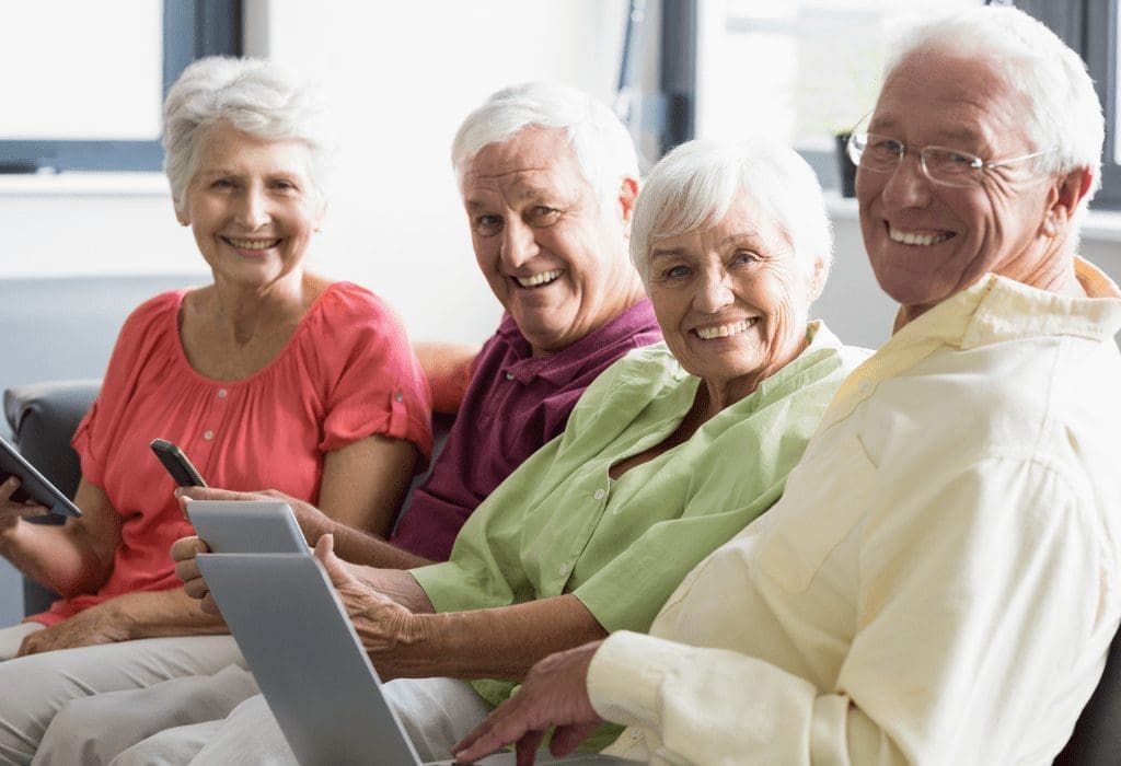 How to Deal with Difficult Neighbors? 1 Four board members delightedly using self-managed condo association software on mobile phones and laptop for efficient community management