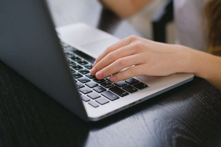 HOA Communication Tools: Person typing on laptop