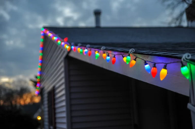 HOA Holidays: A house adorned with vibrant Christmas lights on its roof.