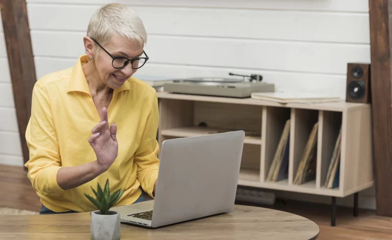 senior woman looking at computer using community association management software